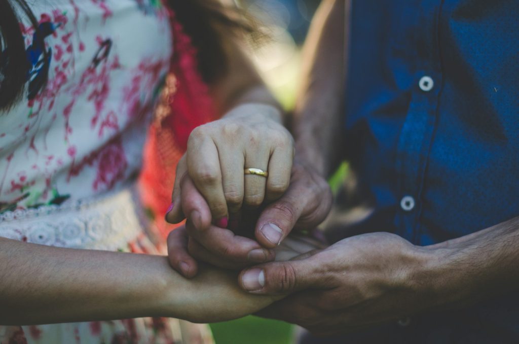 person in blue shirt holding hands
