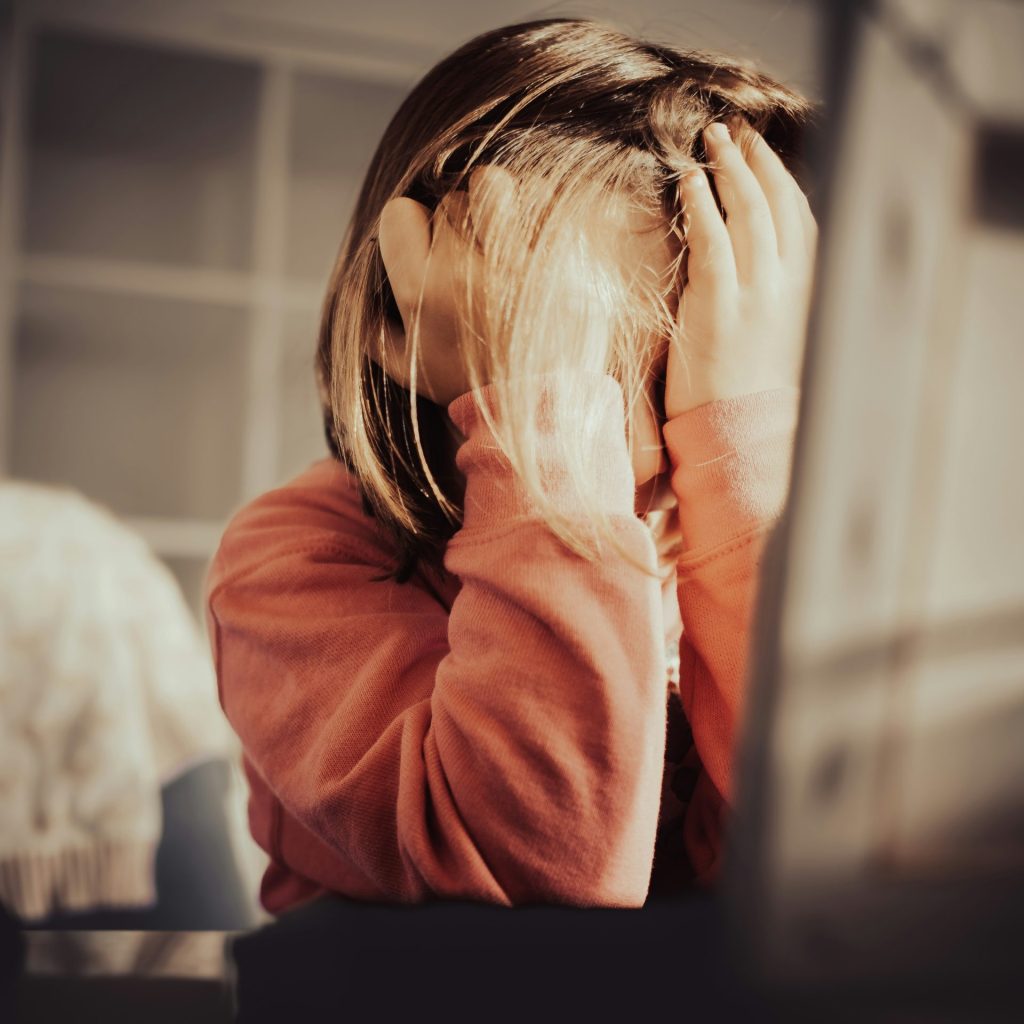 a little girl sitting in front of a laptop computer