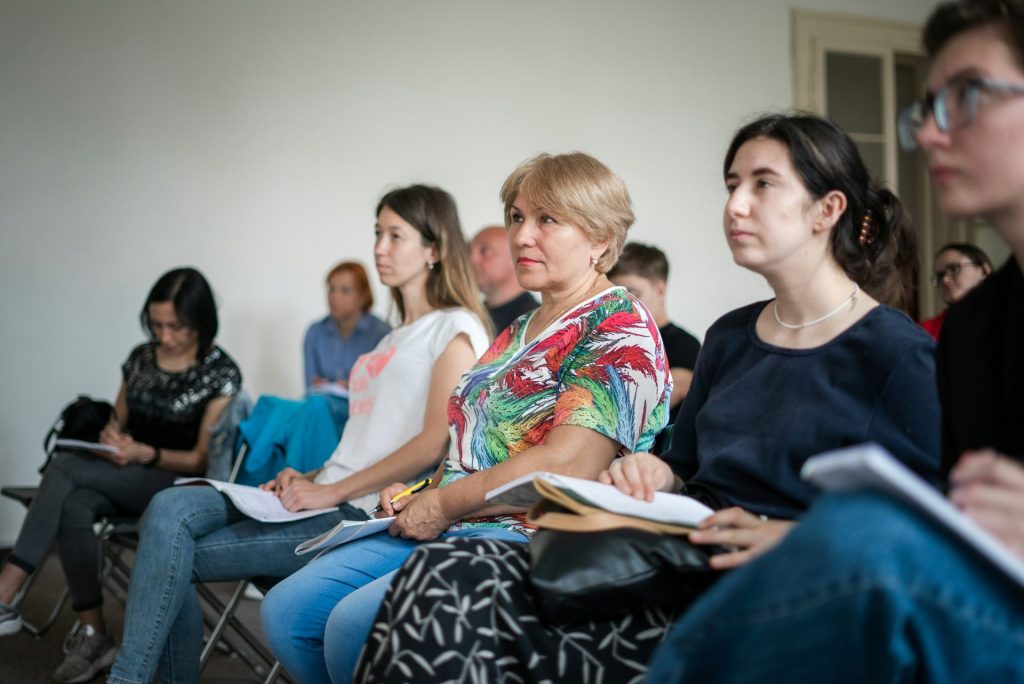 eine Gruppe von Menschen, die auf Stühlen sitzen